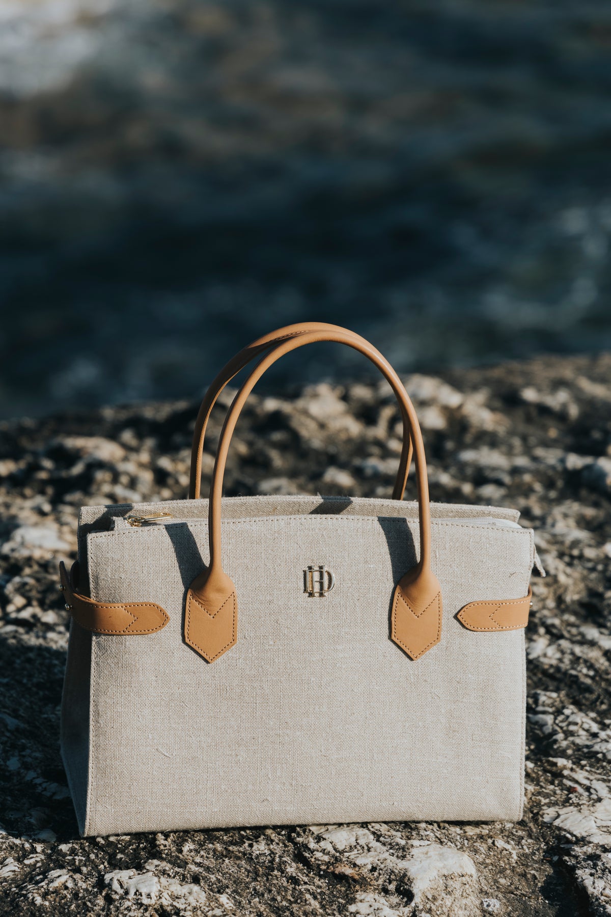 Linen and leather shoulder bag worn on the coast, D'Heritage Summer 2026